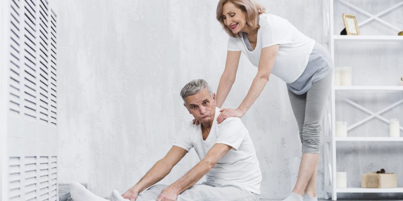 joyful-senior-couple-making-fun-while-exercising-home