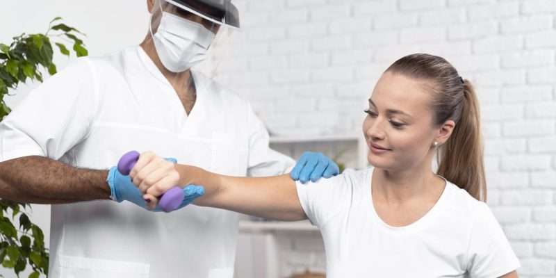 male-physiotherapist-checking-woman-s-arm